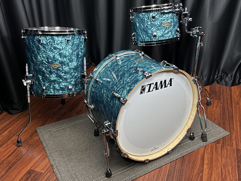Tama Walnut Birch three piece set in turquoise pearl finish with chrome hardware. Twelve inch tom. sixteen inch floor tom. twenty two inch bass drum