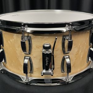Ludwig classic maple six point five by fourteen snare drum with birdseye inner and outer plies in natural gloss finish showing throw off